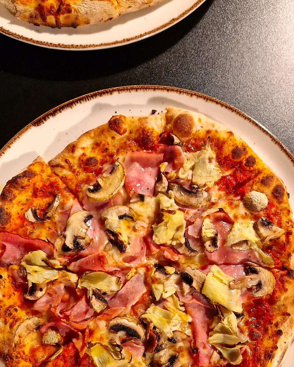 Pizza mit Schinken, Champignons und Artischocken